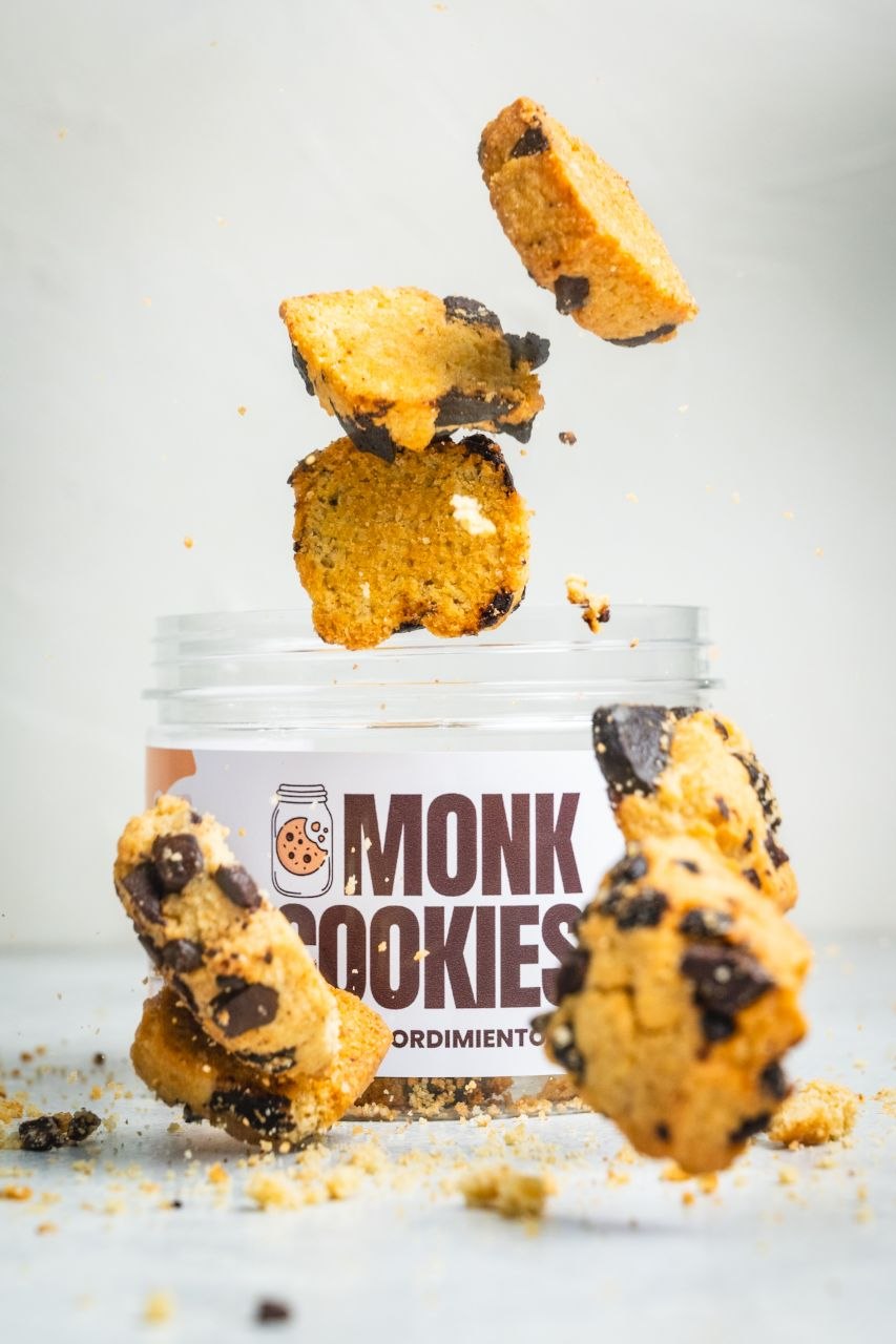 Galletas Monk Cookies flotando sobre el pote
